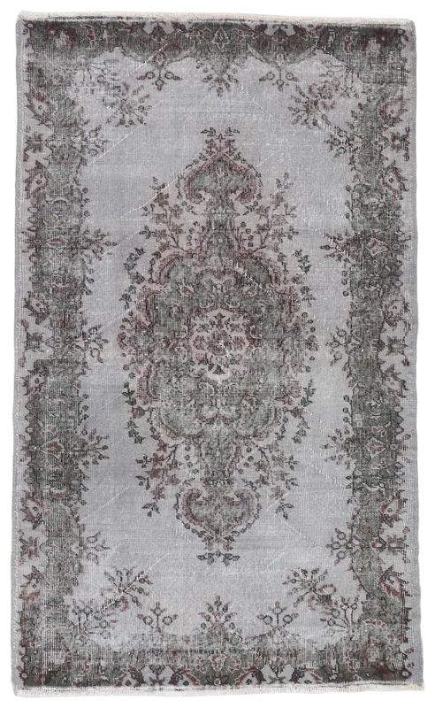 Full overhead view of the vintage gray and charcoal medallion rug on a white background