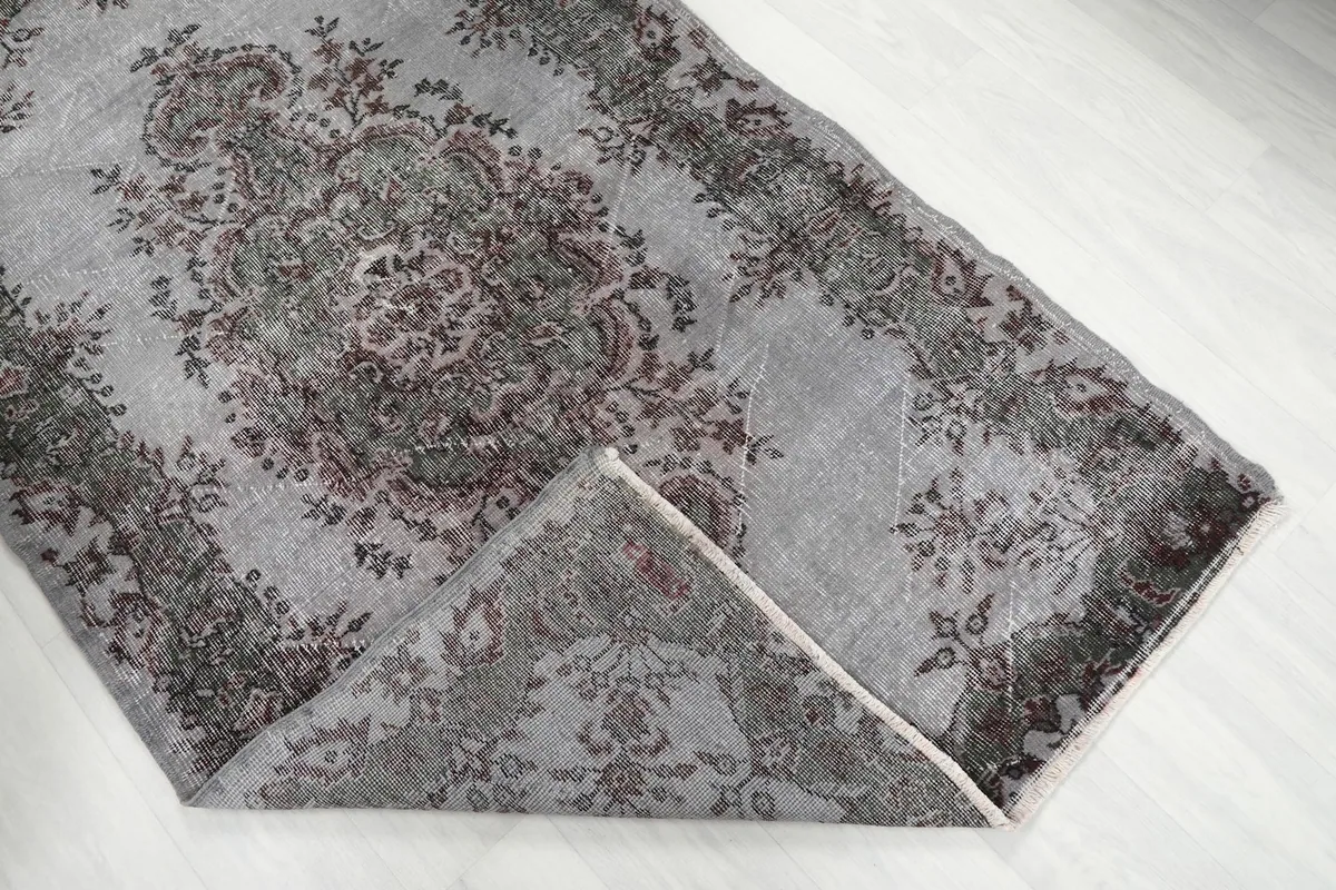 Folded corner of the rug, showing the wool pile and cotton foundation from the side