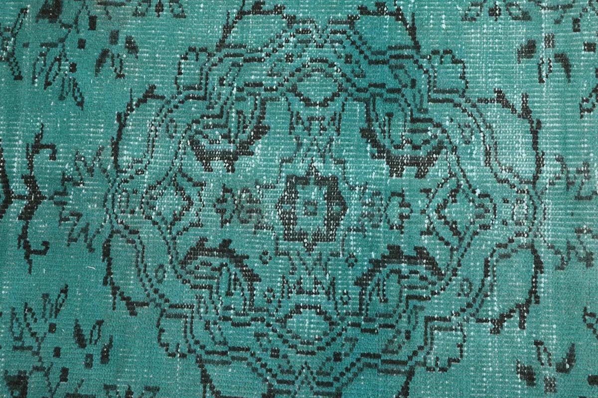 Detailed view of the intricate black medallion pattern and blue tones of the rug's pile