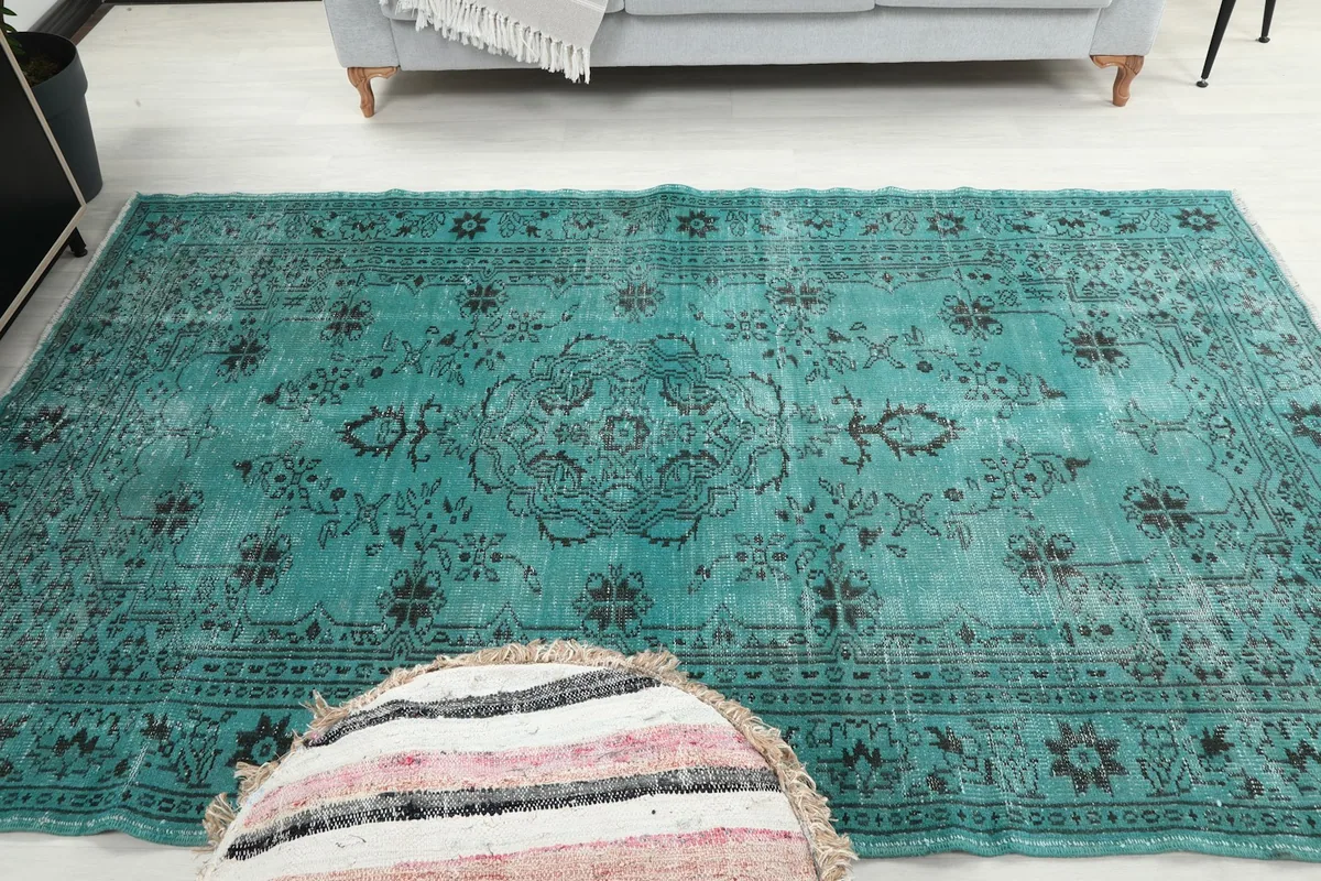 Full overhead shot of the blue and black vintage rug on a light floor in a room setting