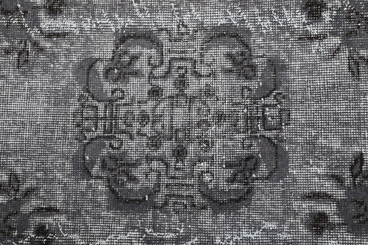 Detailed view of the intricate central medallion and its surrounding faded motifs