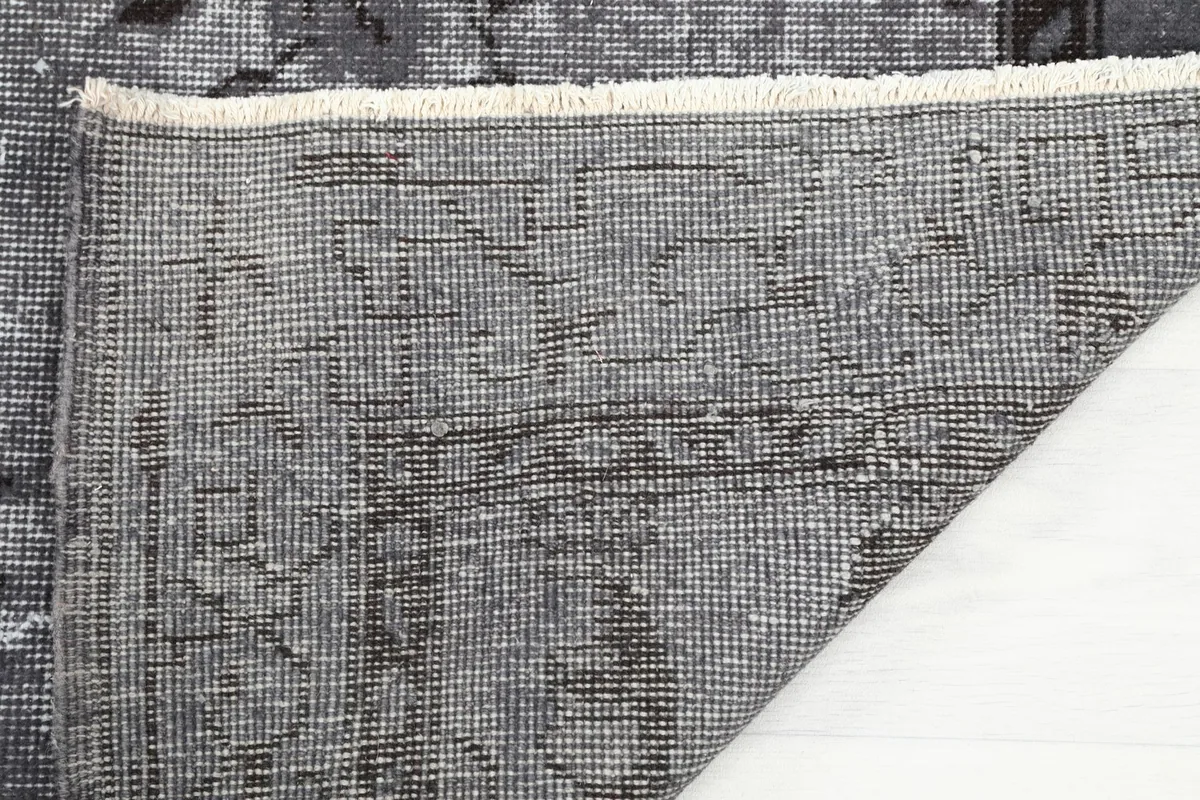 Underside of the rug, showing the hand-knotted cotton foundation and fringe detail