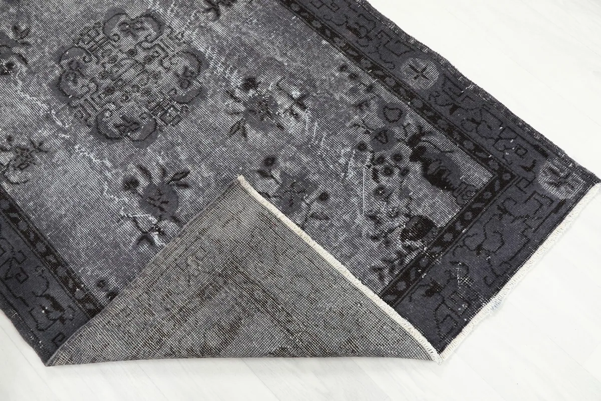 Folded corner of the rug, revealing the wool pile and cotton foundation texture