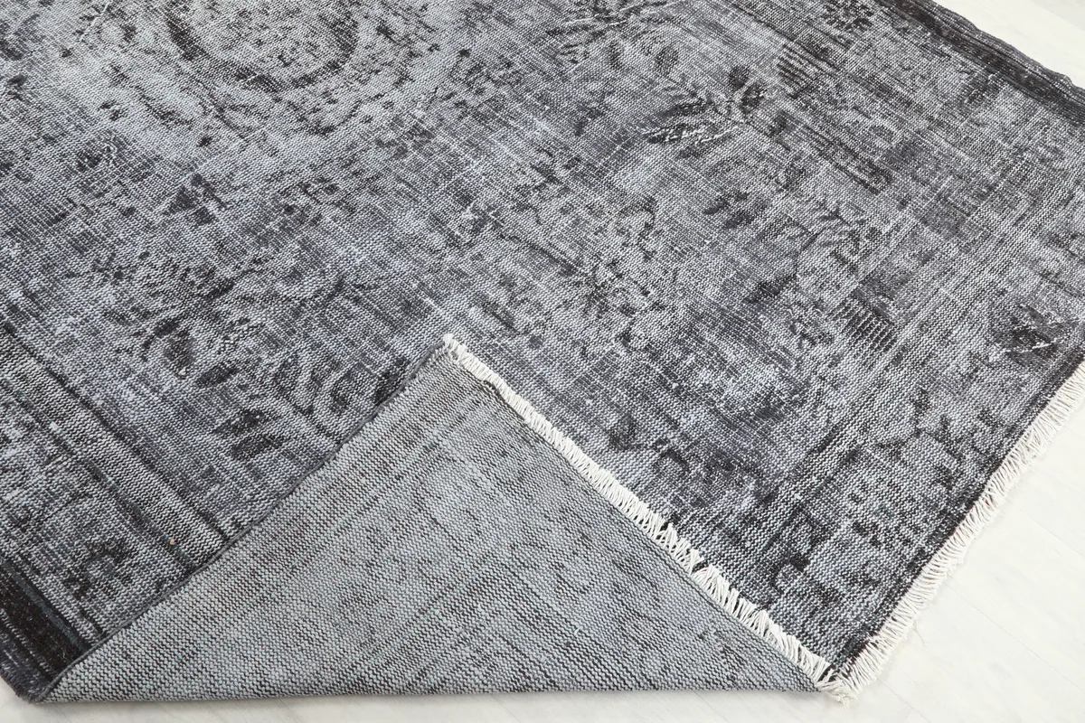 Corner of the Charcoal Medallion Anatolian Rug folded back to show the cotton foundation