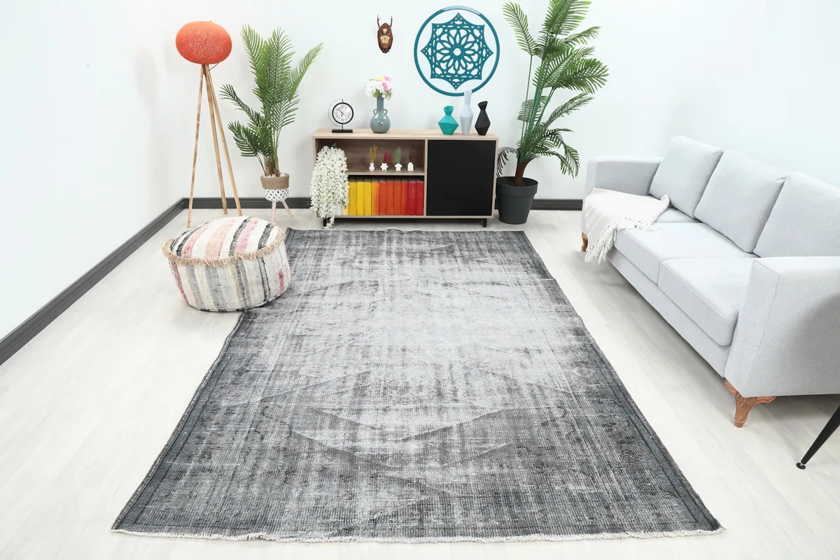 Vintage gray area rug placed in a modern living room setting with a sofa and ottoman