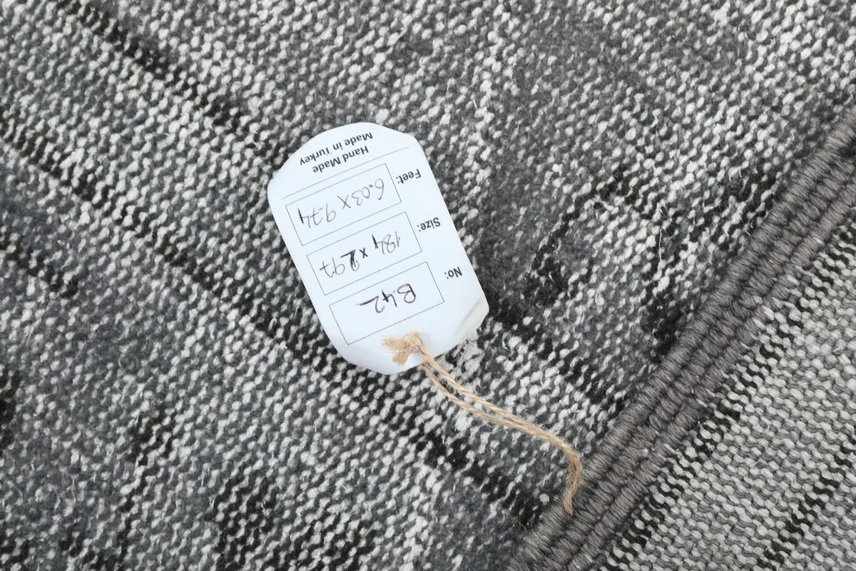 Product tag on the back of the rug, displaying size and material information