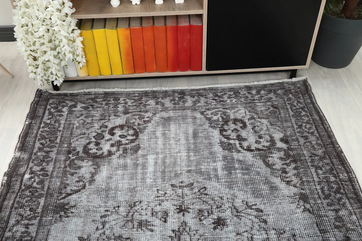 Room view showing the top section of the gray rug, with furniture in the background.
