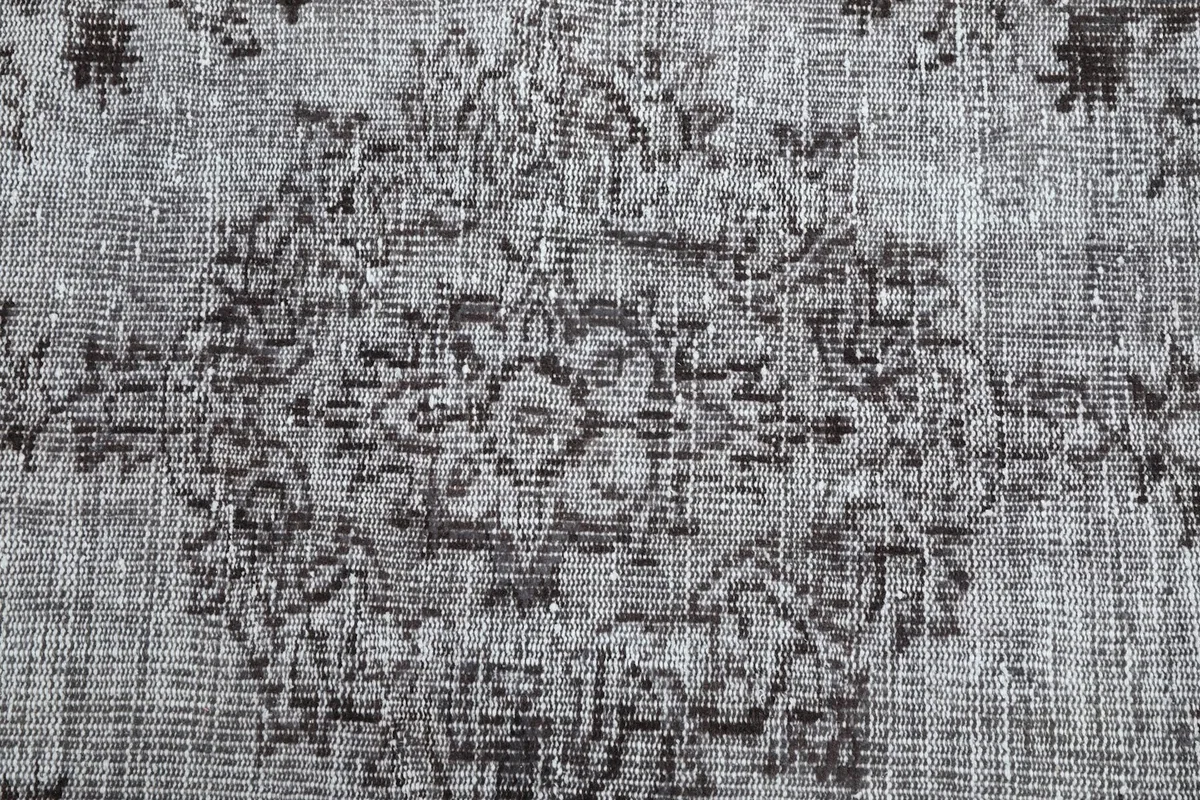Detailed close-up of the central medallion motif, highlighting the intricate knotting and color variations.