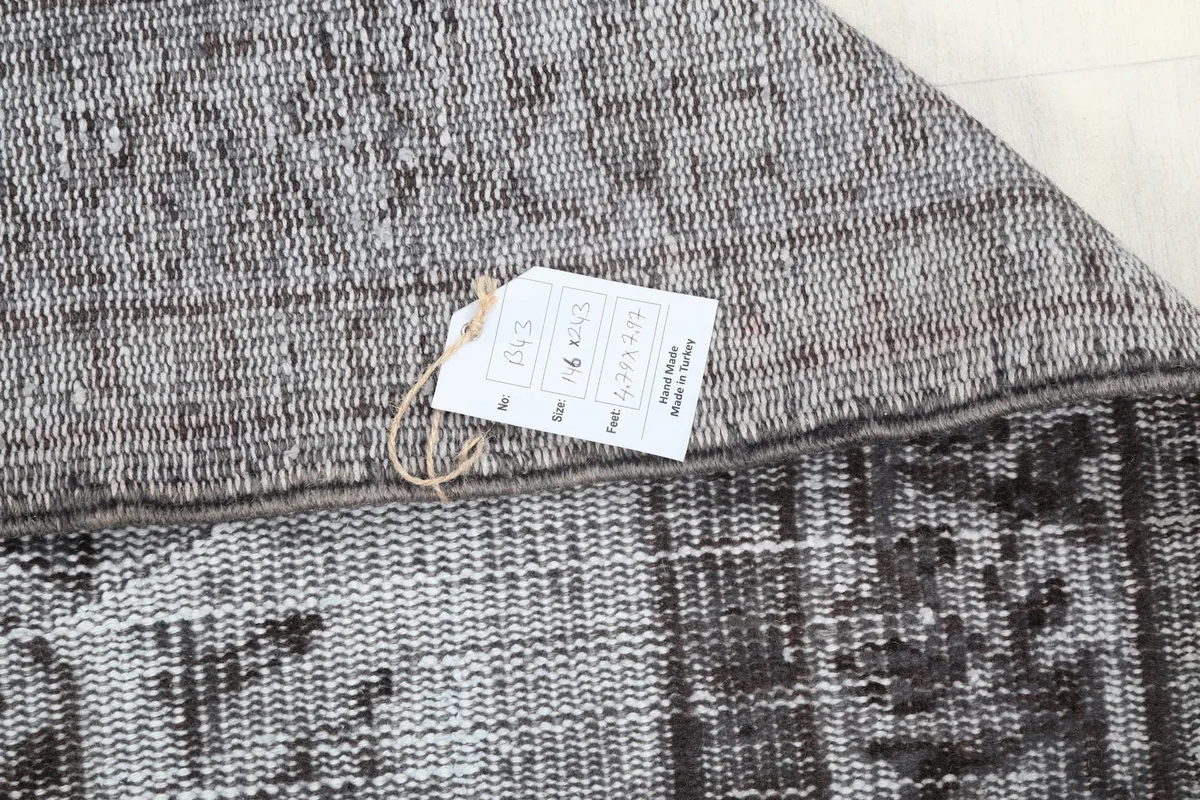 Detail of the rug's back with a product tag, indicating its origin and material.