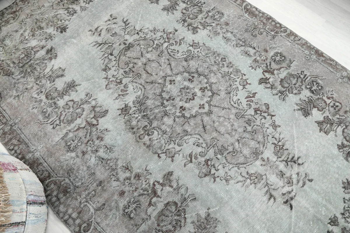 Overhead angle shot highlighting the rug's faded central medallion and border design