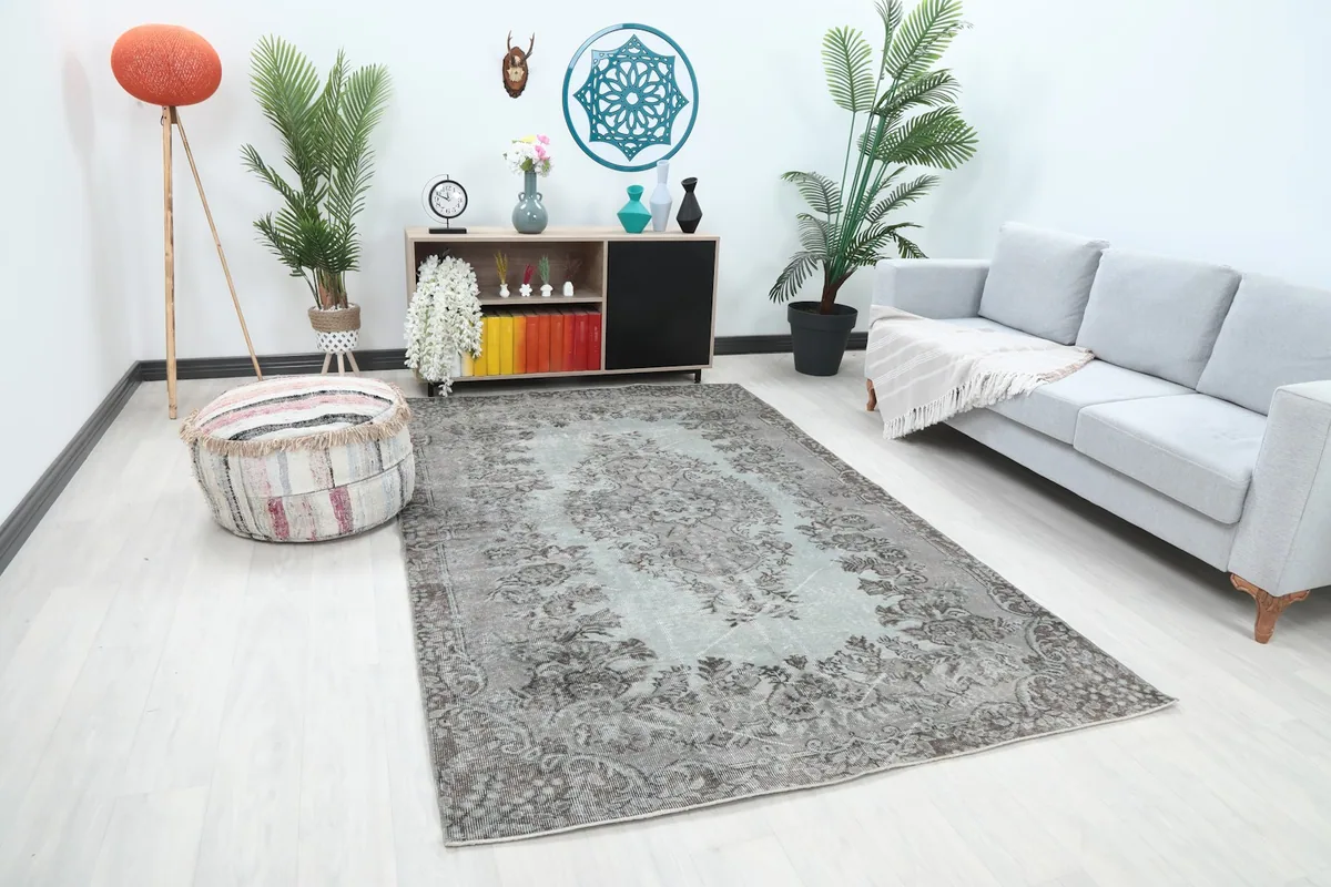 Area rug in a room, showing its placement in front of a sofa and a decorative pouf