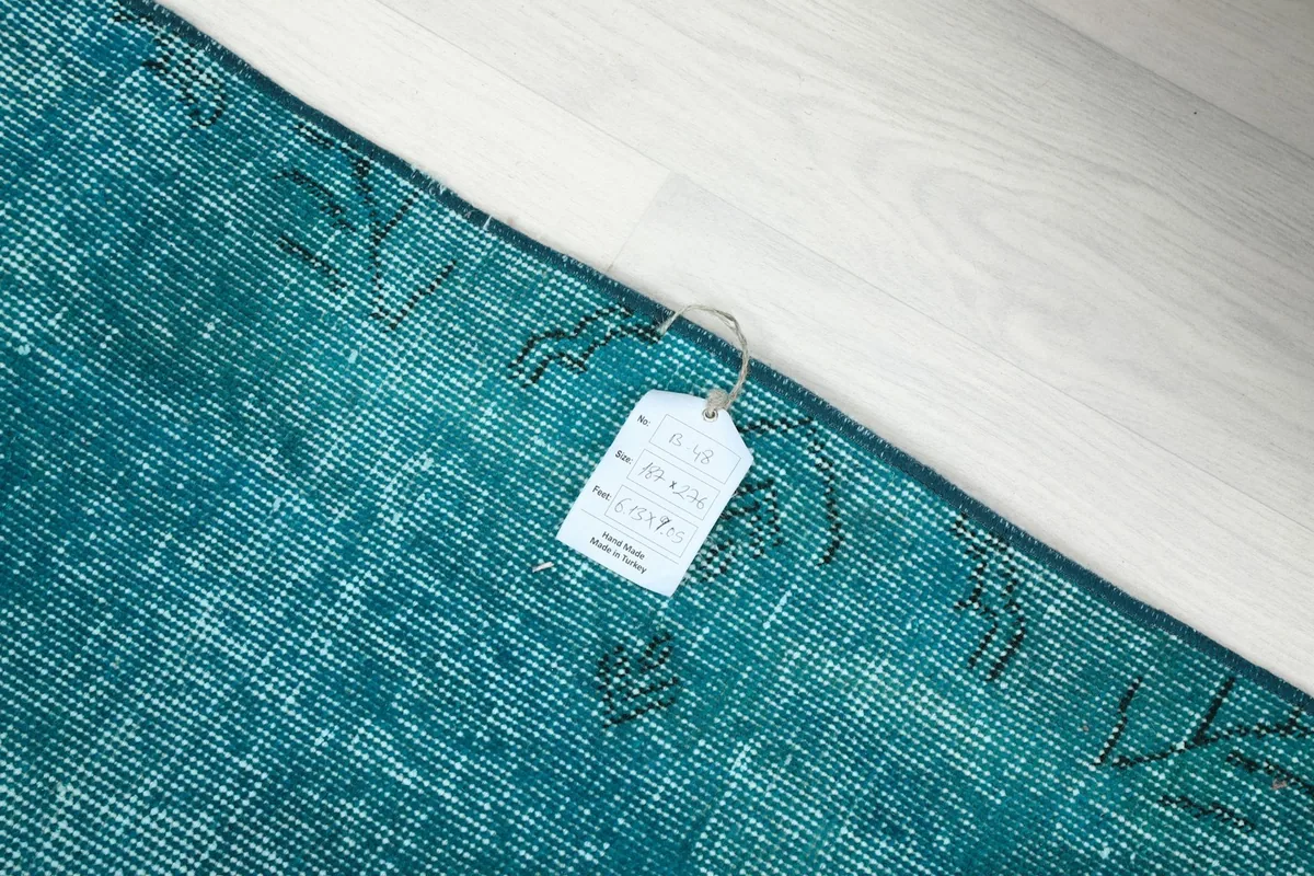 Corner of the rug with a product tag, showing the natural fringe and weave