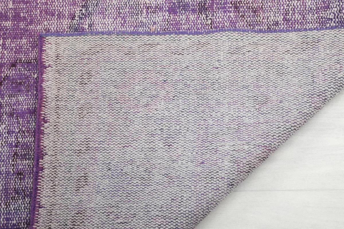 Close-up of the rug's reverse side, showing the tightly woven cotton foundation
