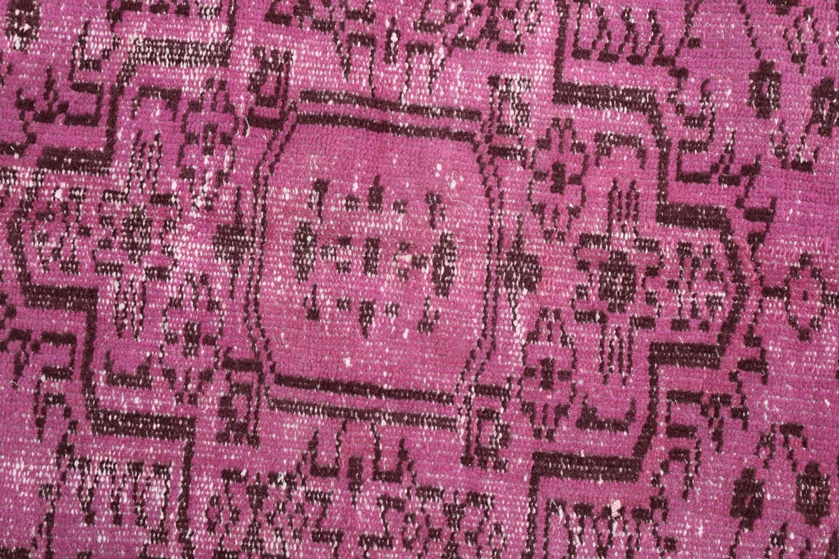 Close-up detail of the central medallion pattern and worn wool pile