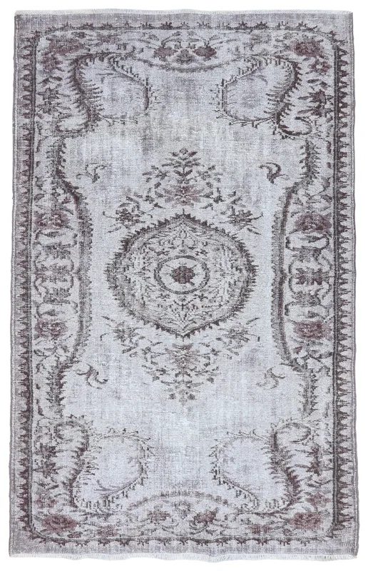 Full overhead view of the gray and brown vintage Anatolian area rug on a white background.