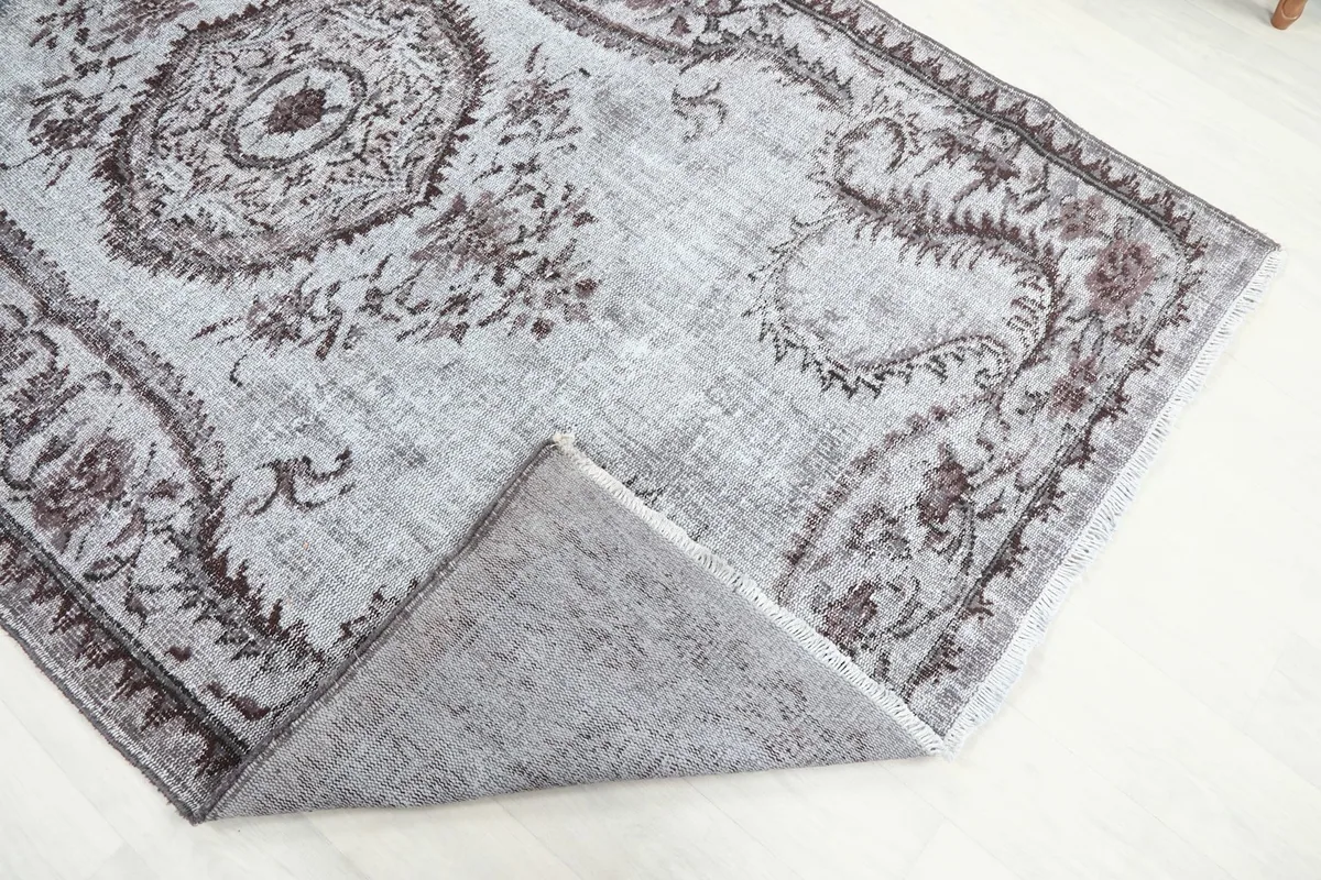 Corner of the rug folded over to show the hand-knotted cotton foundation.