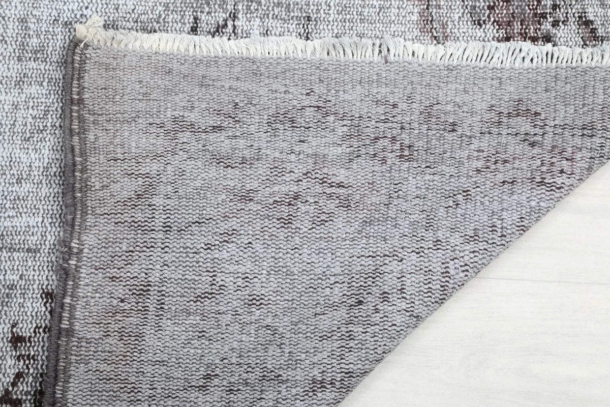 Close-up of the back of the rug and the short, natural fringe.