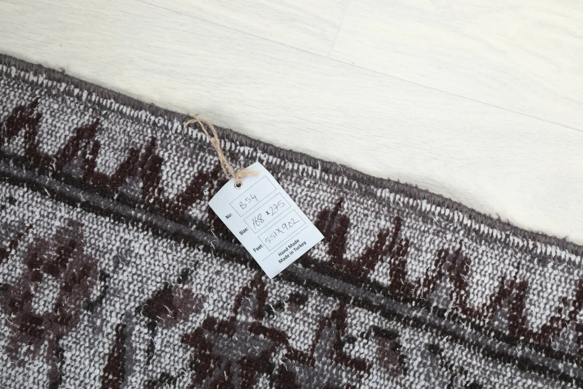 Detail showing the RugsKilim product tag attached to the rug's border.