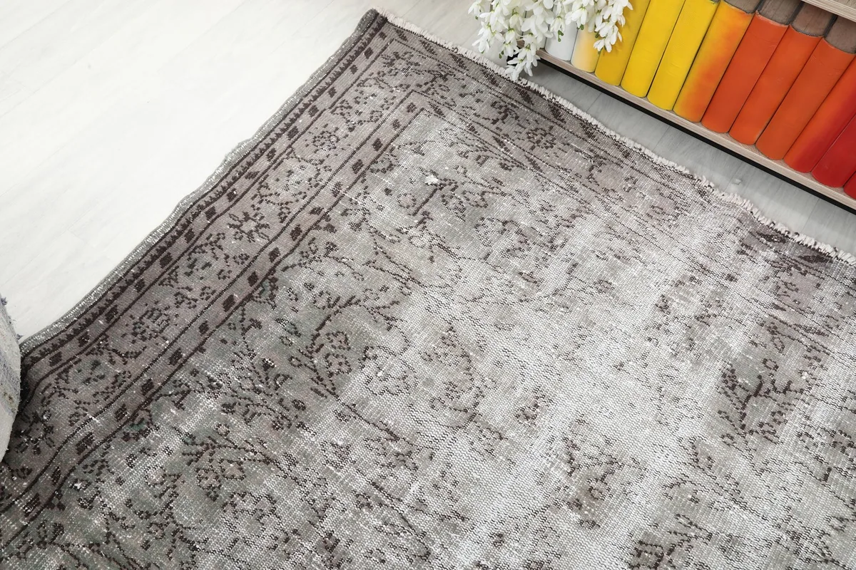 Angled view showing the rug's border and field, with light visible distressing