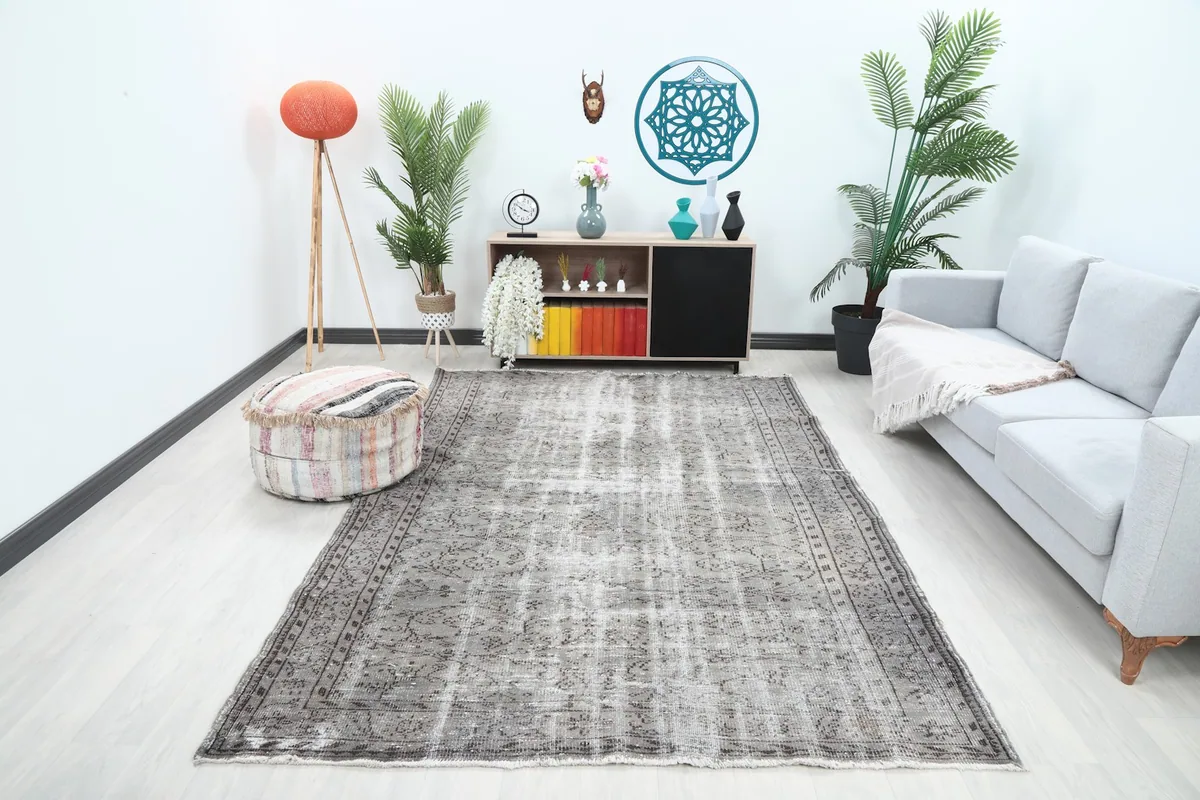 Gray vintage rug placed in a modern living room setting with a light sofa