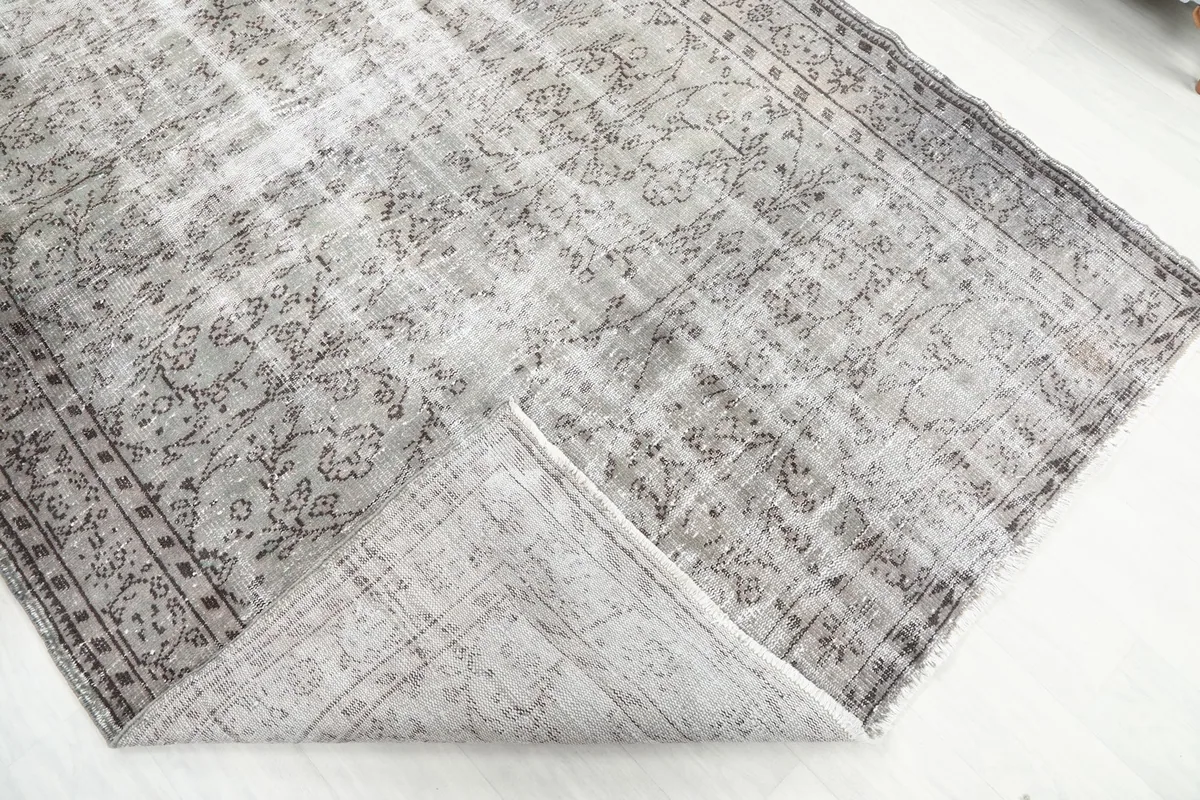 Folded corner of the rug, revealing the wool pile and cotton foundation construction