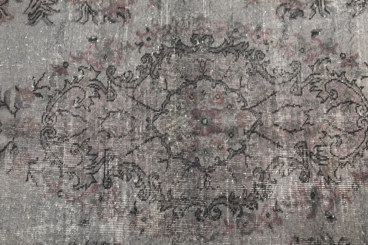 Close-up detail of the central medallion and faded floral patterns