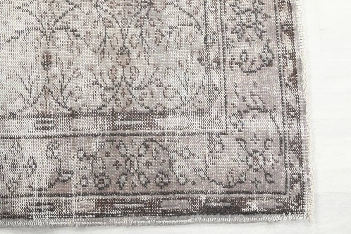 Detailed corner view of the rug, highlighting the subtle floral and geometric motifs and border