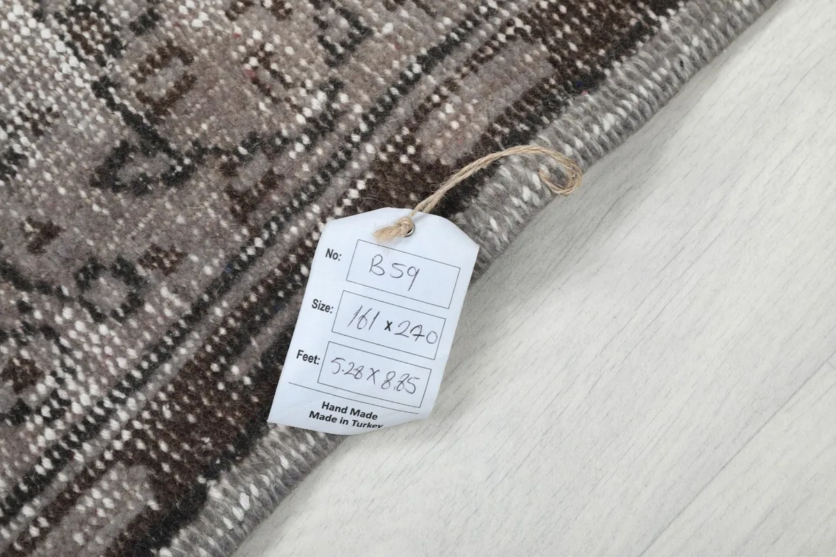 Label attached to the rug, indicating its size in feet and centimeters and origin