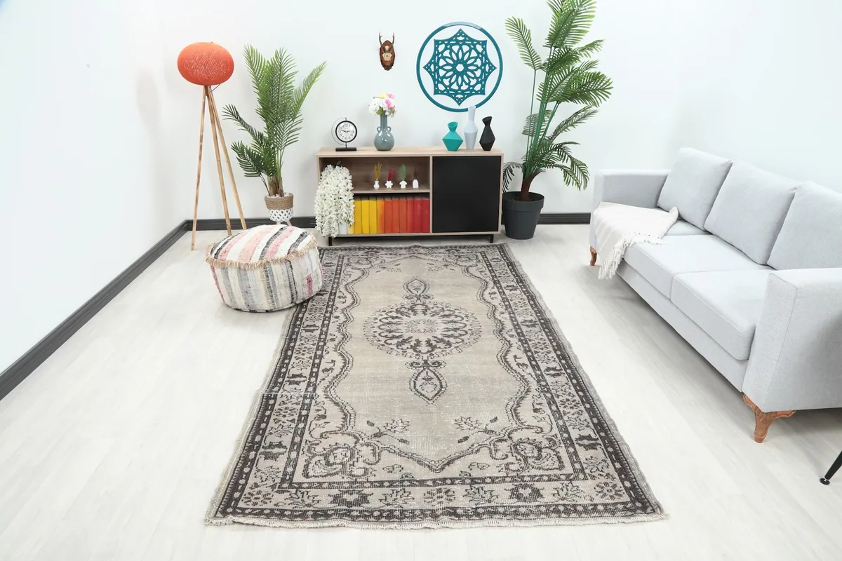 Vintage Anatolian rug displayed in a living room setting with a sofa and decor