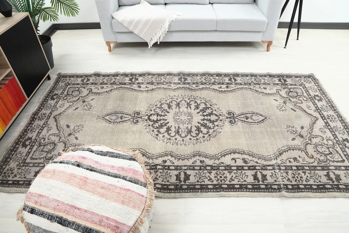 Full view of the vintage area rug in a living room with sofa and side table