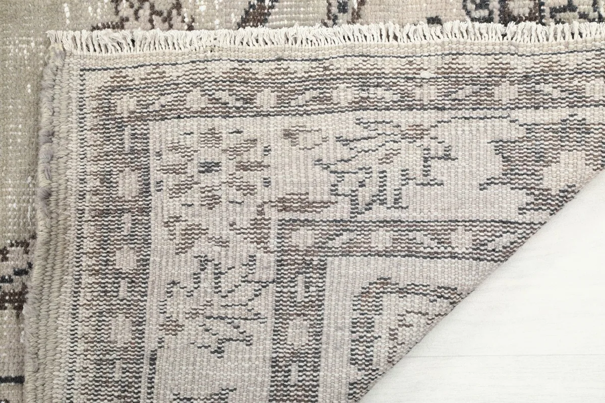 Close-up of the back of the hand-knotted rug, showing the cotton foundation