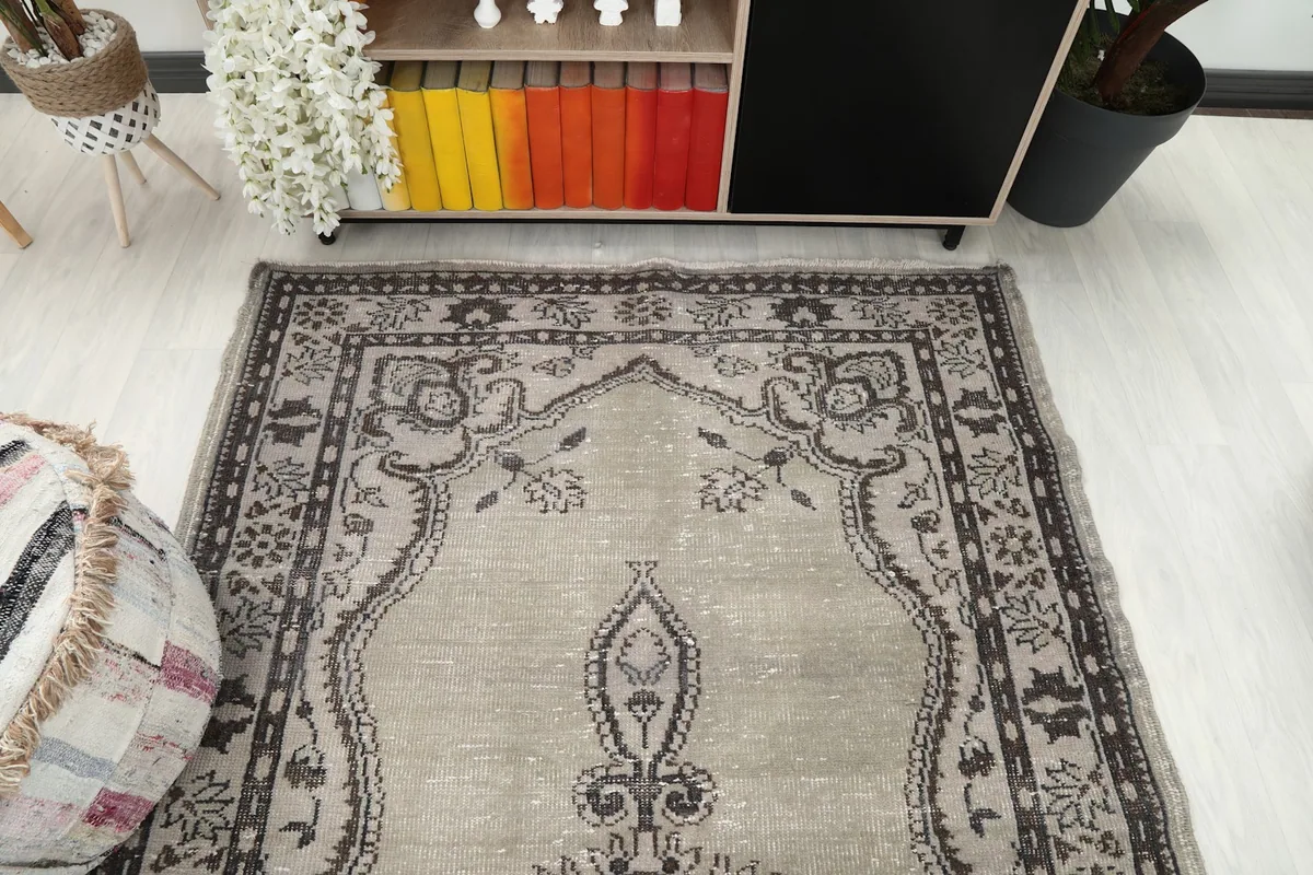 Overhead view of the upper half of the rug showing its patterns in a room