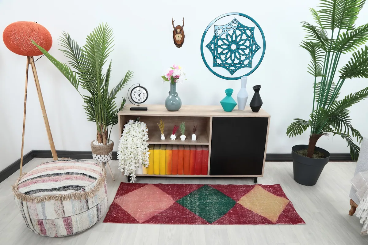 Runner rug placed in a room setting in front of a console table with plants and decor.