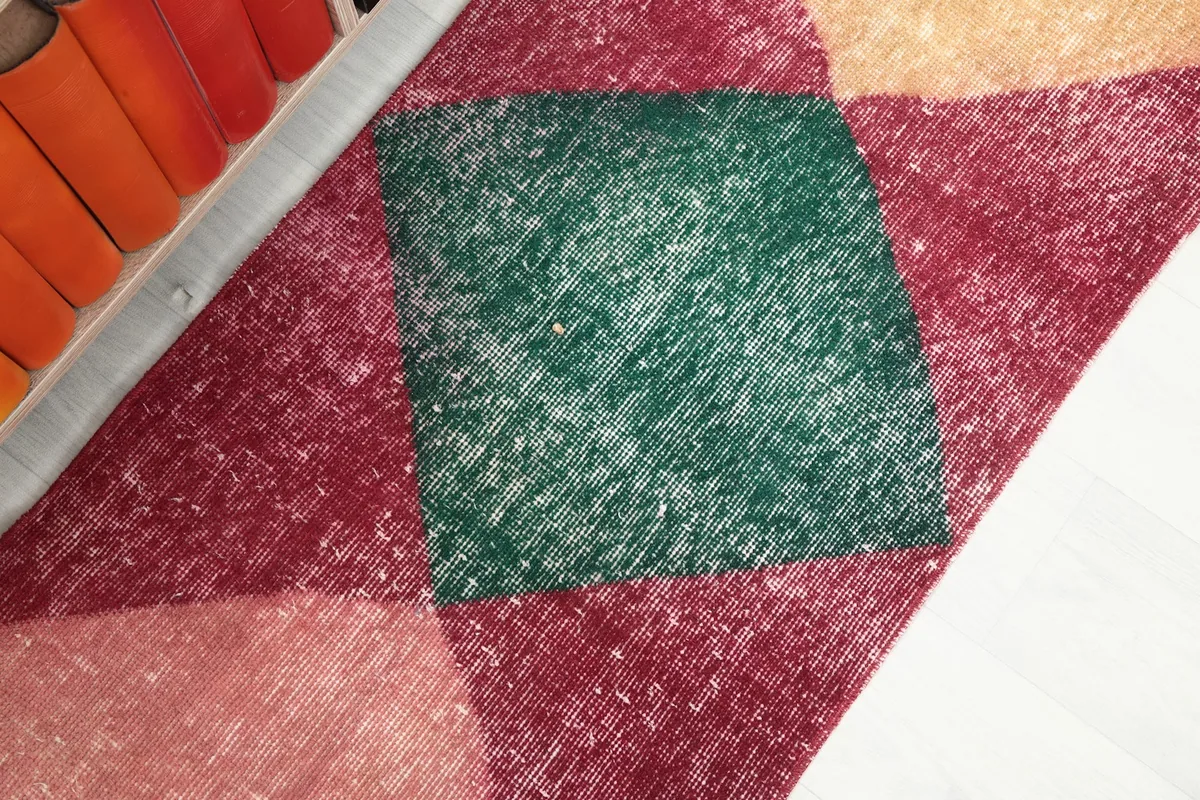 Close-up detail of the green diamond section and surrounding red field, showing texture and patina.