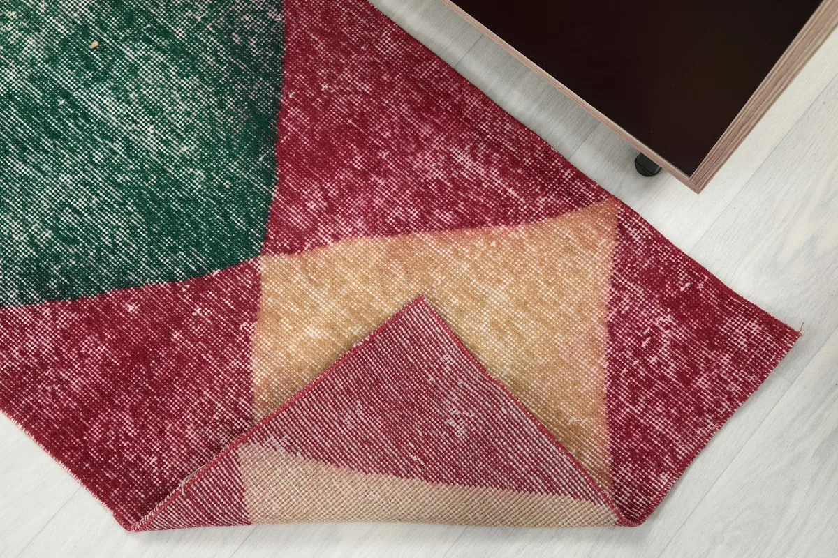 Corner of the runner rug folded back to show the wool pile and cotton foundation.