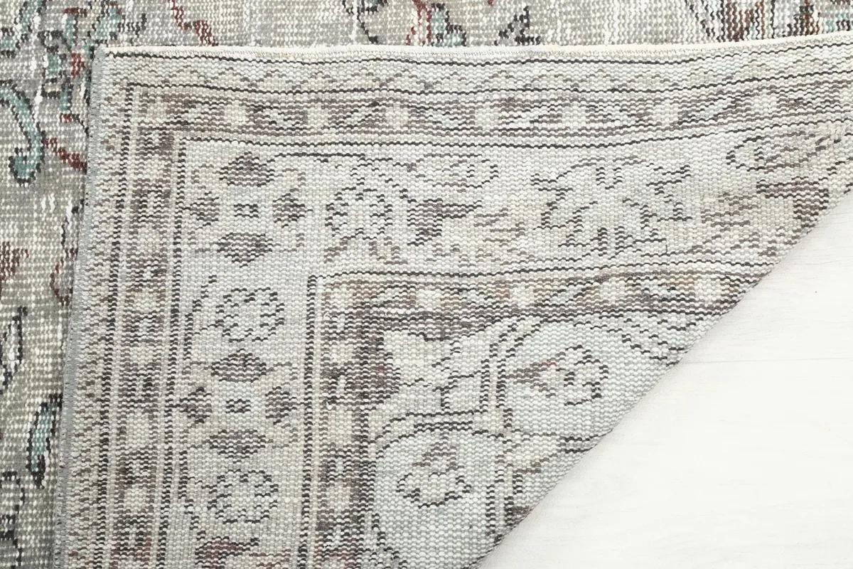 Close-up of the back of the rug, showing the hand-knotted cotton foundation