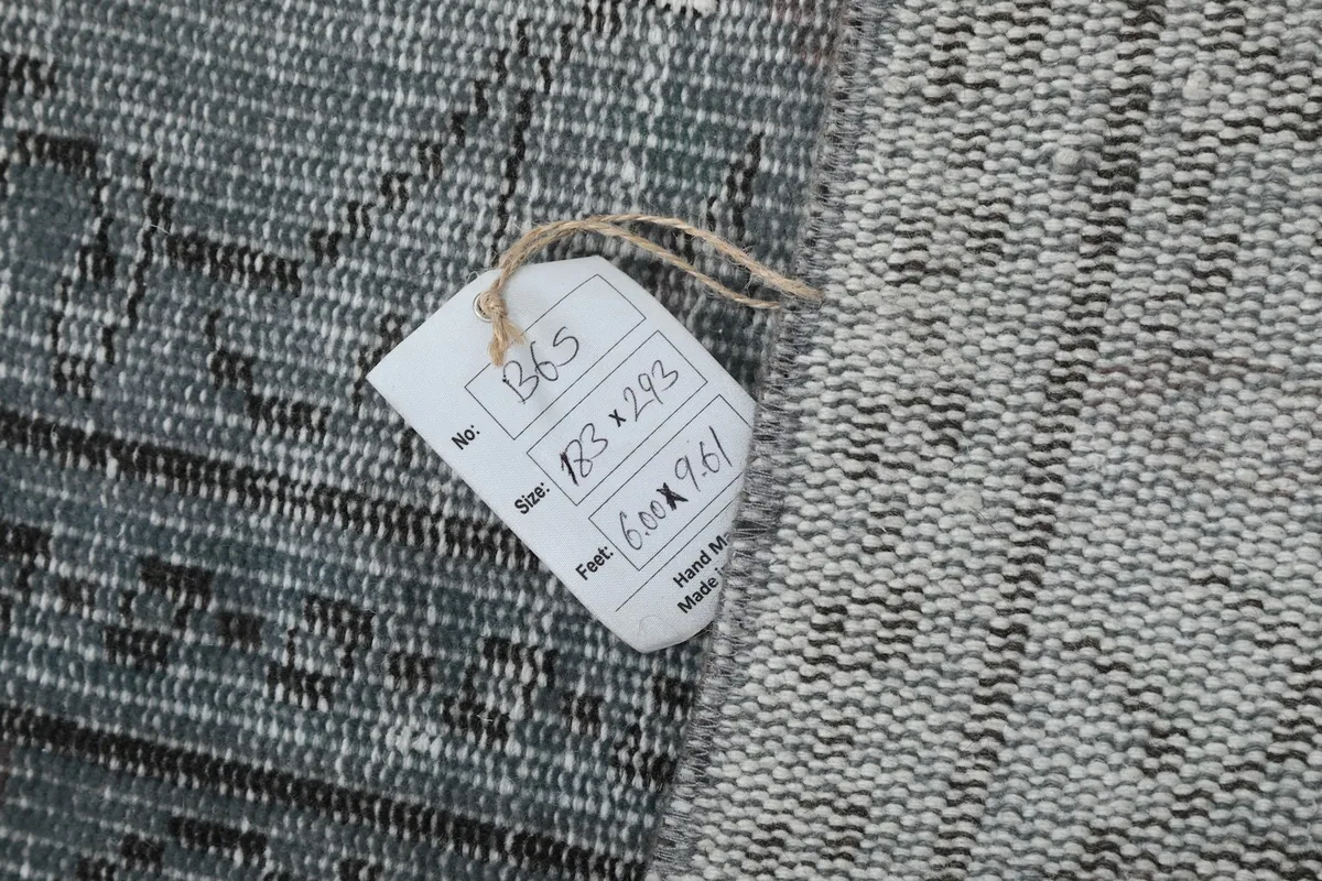 Close-up of the product tag attached to the rug, displaying size and origin information