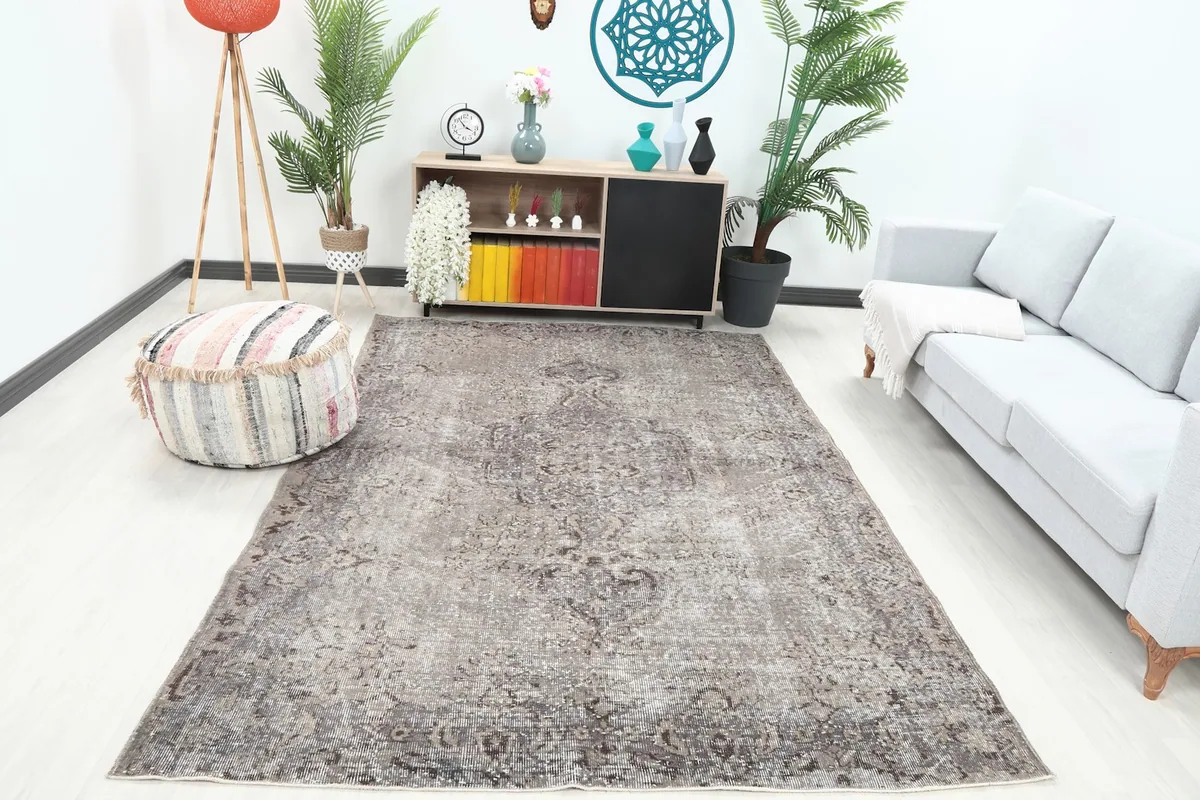 Charcoal gray vintage rug displayed in a living room setting with a light sofa