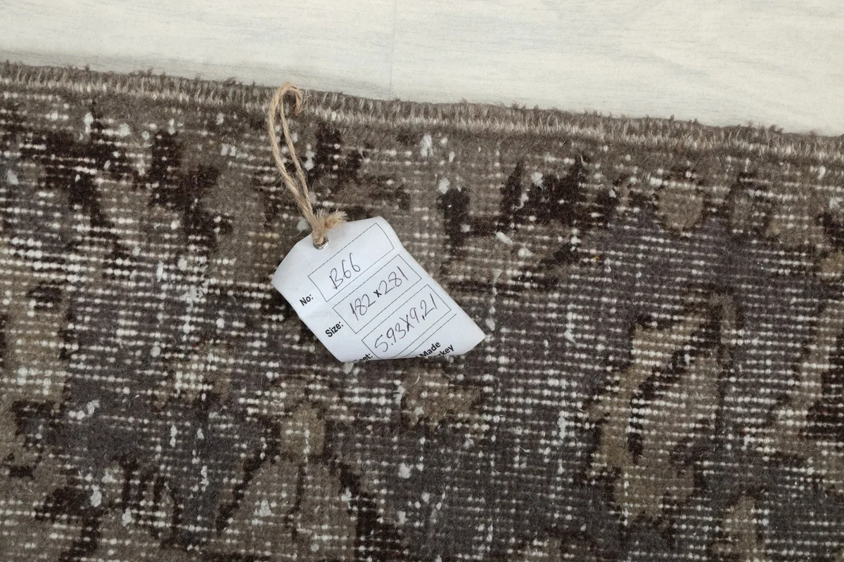 Close-up of the rug's edge with a tag showing size information