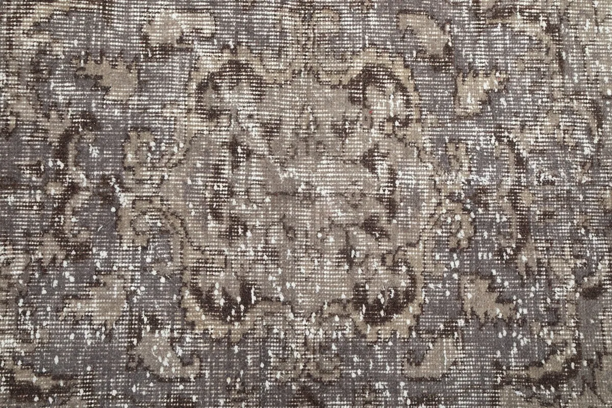 Overhead close-up of the low wool pile, revealing the hand-knotted texture and distressed areas