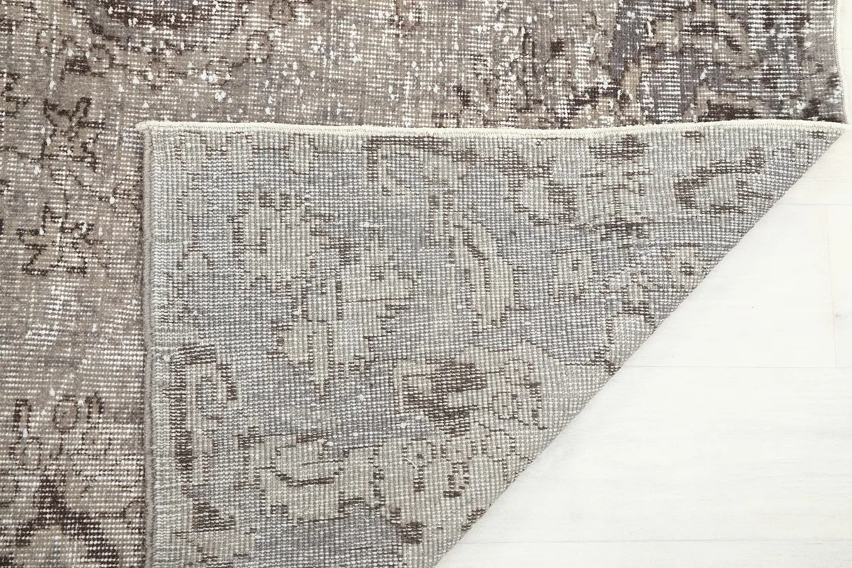 Close-up of the rug's underside, revealing the hand-knotted construction on the cotton foundation