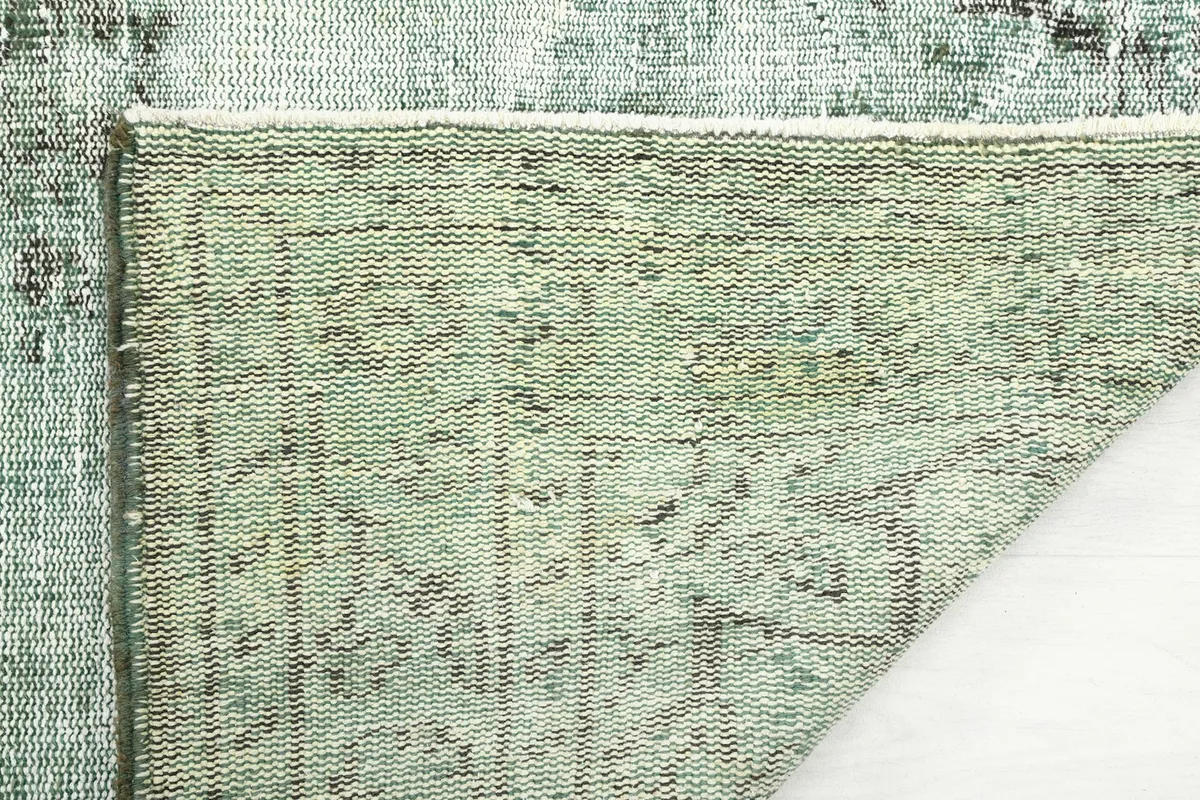 Close-up of the rug's underside, showcasing the hand-knotted cotton foundation and the tight weave.