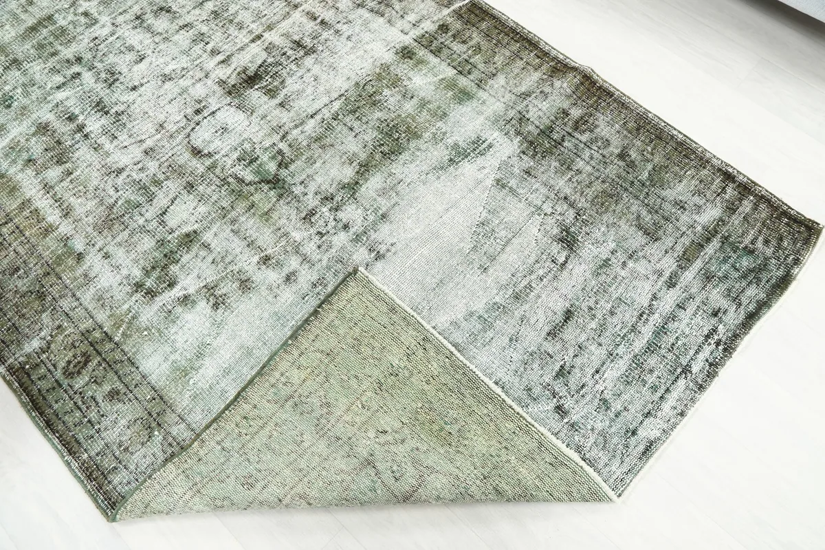 Corner of the rug folded back to reveal the cotton foundation and the reverse side's weave.