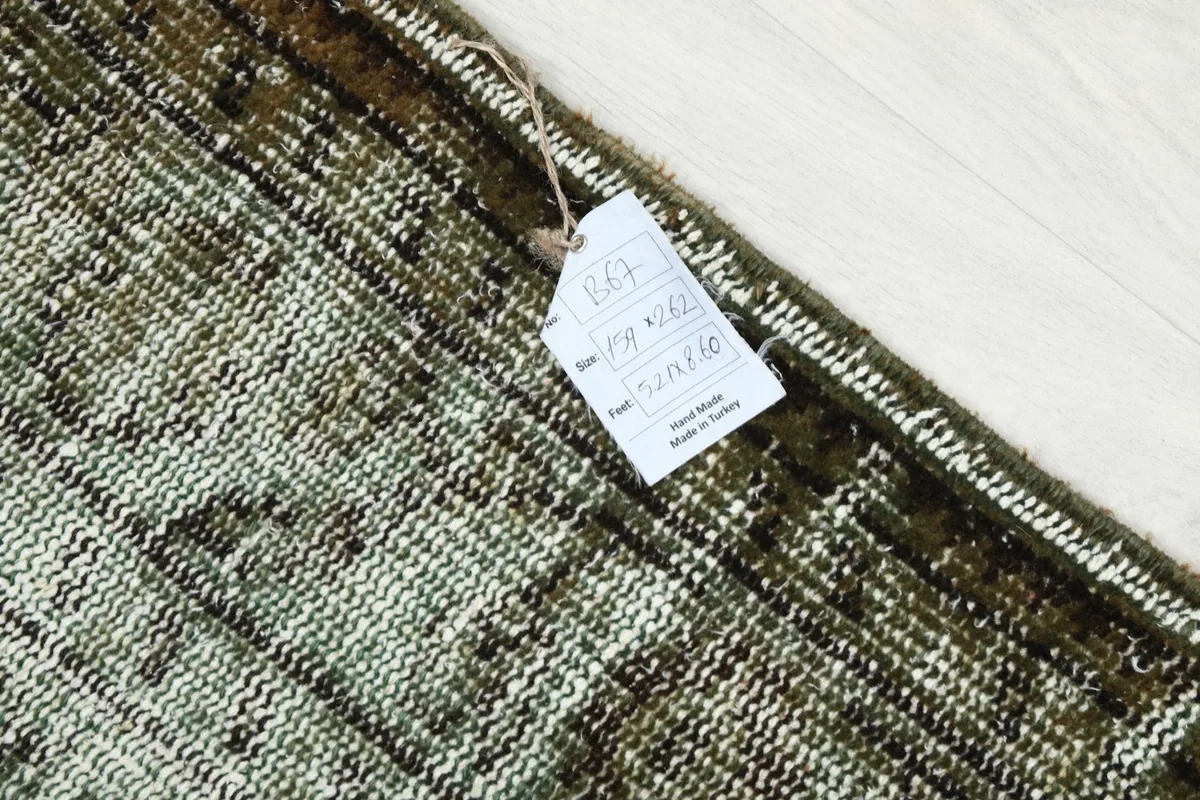 Detail of the rug's surface with a product tag, indicating origin and dimensions.