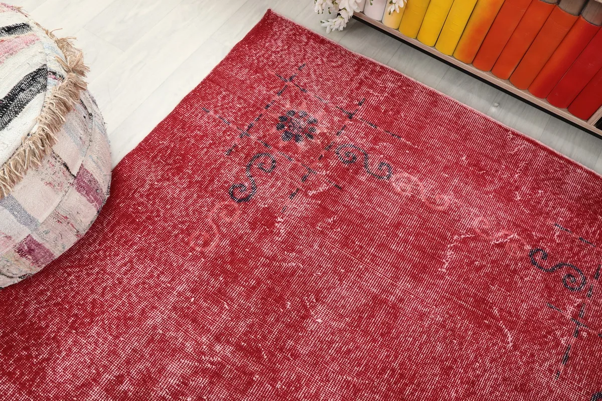 Overhead angle showing the texture and faded patterns of the red vintage rug.