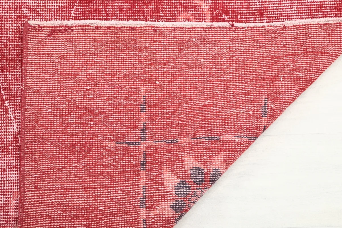 Close-up of the back of the hand-knotted wool rug, showing the cotton foundation.