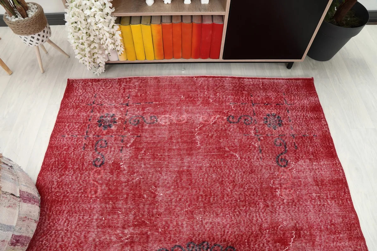 Overhead view of a section of the red rug, highlighting the field and corner motifs.