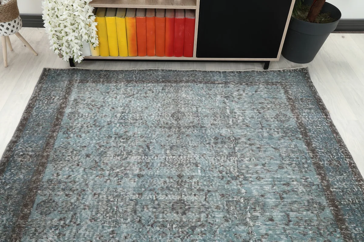 Overhead view of the blue rug positioned near a cabinet with colorful books