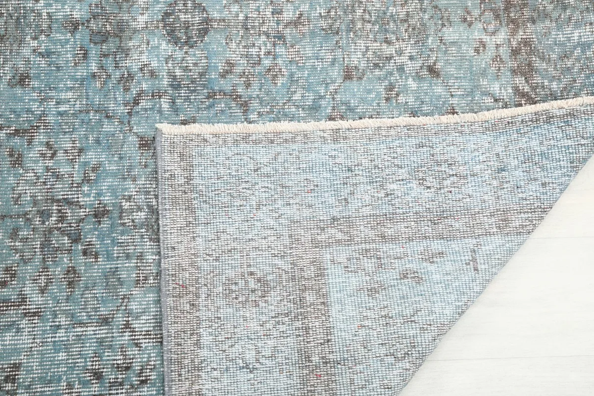 Close-up of the rug's reverse side, showing the hand-knotted construction and foundation