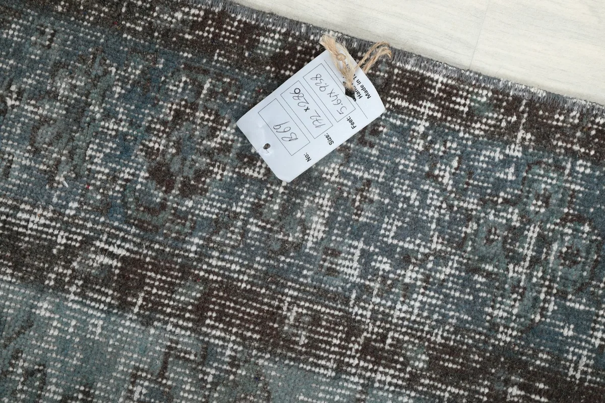 Close-up of the rug's surface with a product tag showing dimensions and details